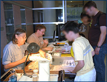 Randy Irmis (left rear) explains the life history of a fossil while Dawn Peterson (left front) carefully frees a bone from its plaster jacket