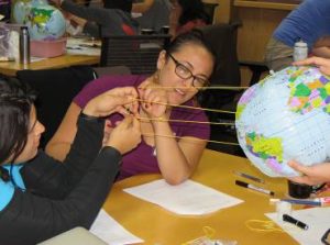 Teachers Monica Sircar (left; Everest Public High School, Redwood City) and Crystina Ayala (ASCEND K-8 School, Oakland) use string to represent rays of sunlight hitting Earth's surface at different angles at different latitudes.