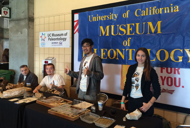 Graduate students (from left to right) Eric Holt, Nick Spano, Jun Lim, and Emily Orzechowski, prepare the exhibit table during Discovery Days at AT&T Park. Photo by Jun Lim