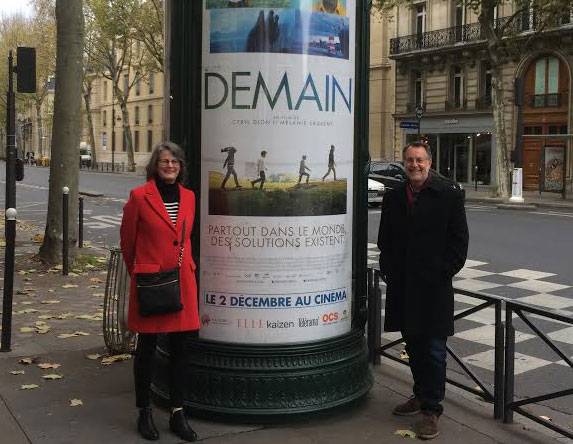 Tony and Liz by billboard advertising the movie Demain, in Paris. 