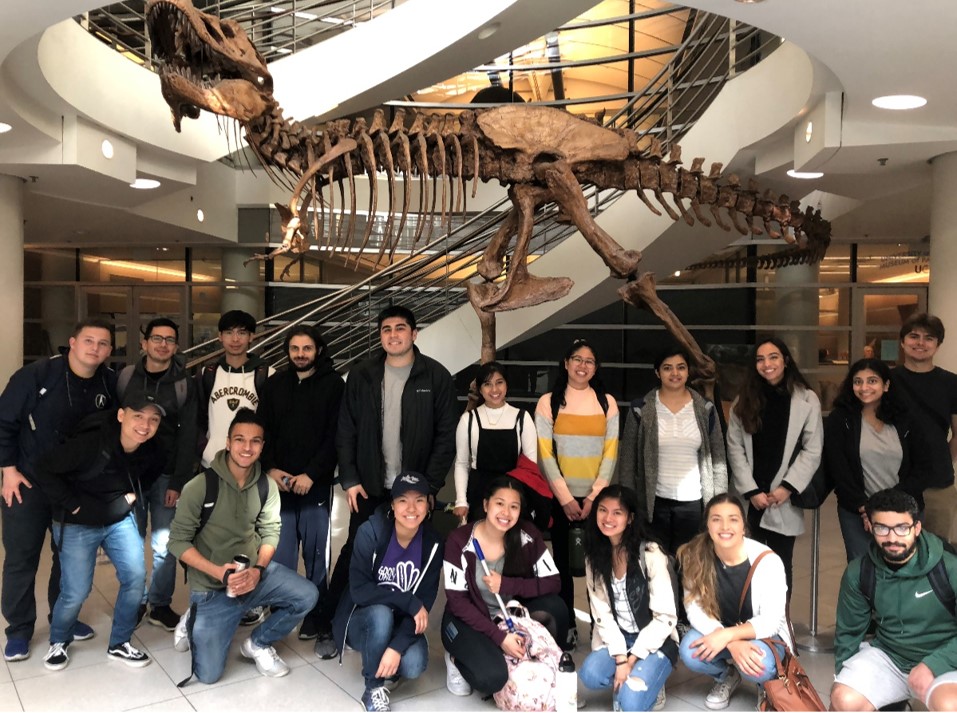 Community college students posing in front of the T. rex outside of the UCMP