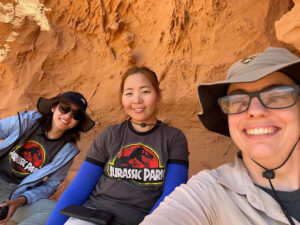 Three women against a orange colored outcrop in Mongolia.