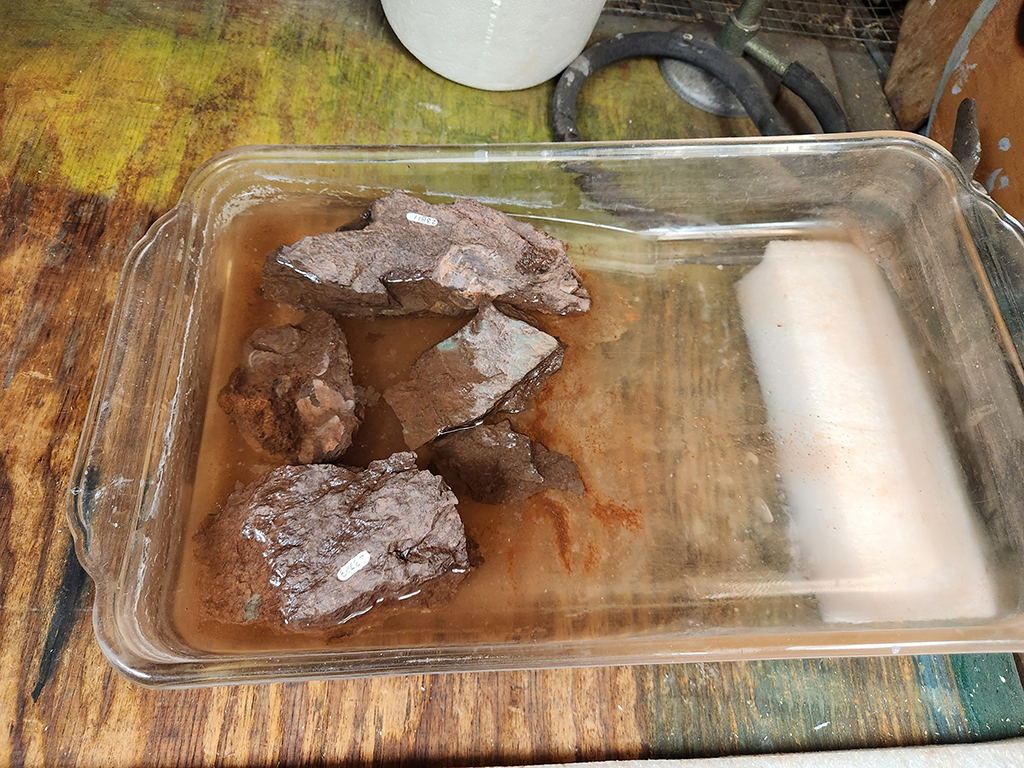 reddish rocks dissolving in acid solution